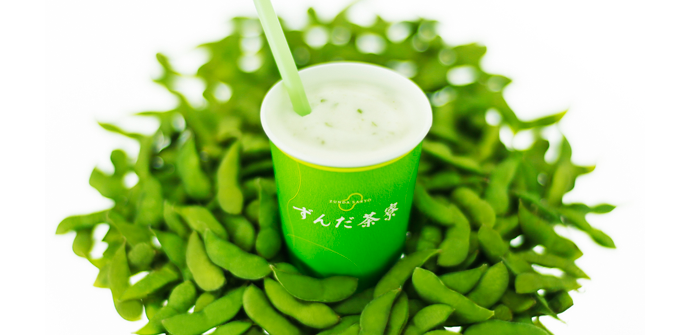 Photograph of a ずんだシェイク (zunda shake), surrounded by a small pool of edamame beans